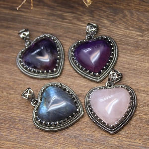 Macro shot of heart-shaped natural crystal pendants on a rustic wooden texture surface