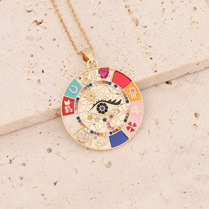 Detail of gold evil eye necklace with colorful enamel lucky symbols on stone background