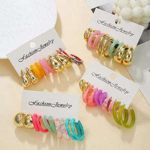 Detailed set of colorful resin and golden metal C-shaped hoop earrings on display cards