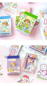 Detailed close-up of cute cartoon girl stickers and mini washi paper journals for DIY craft