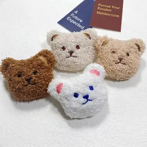 Detail of soft plush teddy bear charms in four colors with embroidered cute facial features
