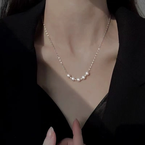 Detailed view of elegant gold lip chain necklace with five luminous round white pearls