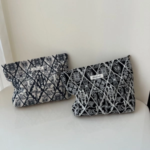 Detail of geometric embroidery on handmade linen makeup bags with simple wish labels