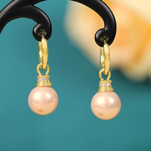 Close-up of pink-gold pearl earrings with sparkling zircon-inlaid 18K gold-plated hoops