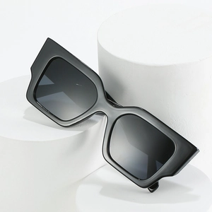 Classic oversized square black sunglasses displayed on white minimalist geometric pillars
