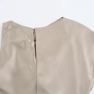 Détail d'une robe en satin avec ouverture au col arrière et texture de tissu lisse et soyeuse