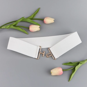 Detailed close-up of white elastic waist belt with gold metal interlocking buckle