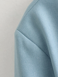 Macro shot of light blue twill fabric and high-quality stitching on bomber jacket sleeves