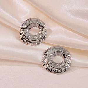 Detailed macro view of silver titanium steel earrings with unique lava textured surface