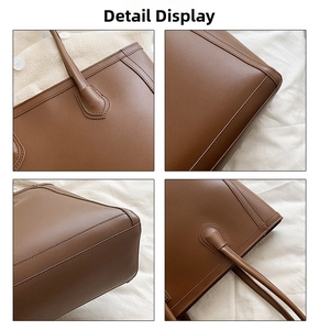 Detail view of reinforced stitching and fine texture on a brown leather tote bag