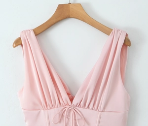 Détail de la robe en satin rose avec col en V, cordon de serrage et plis aux épaules