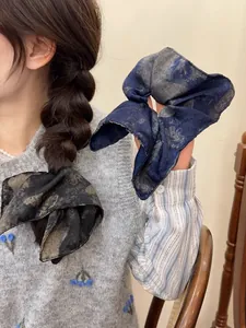 Detail of vintage patterned oversized scrunchies in dark blue and brown silk-like fabric