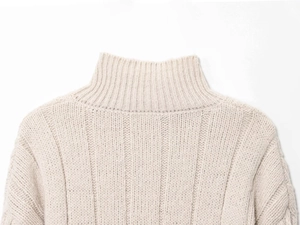 Macro detail of high-quality cable knit texture on a beige zip-up high collar cardigan