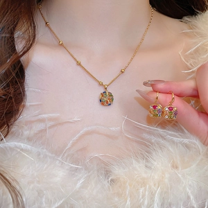 Detail of gold-plated necklace and earrings set with colorful mosaic zircons on a model