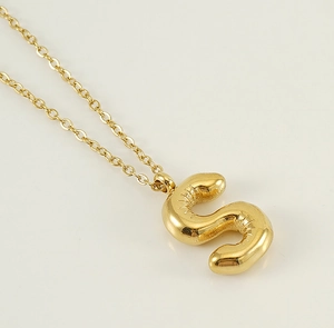Détail du pendentif lettre S dorée style ballon 3D avec texture plissée et chaîne fine