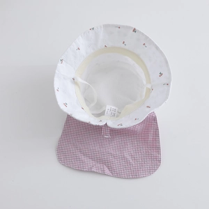 Detail of baby sun hat featuring breathable mesh lining, cherry print, and lace edges
