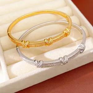 Elegant 18k gold plated X-shaped buckle bracelets with sparkling zircon stones in a jewelry box