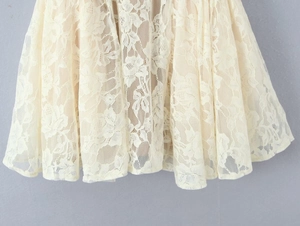 Detailed close-up of white floral lace hem and mesh texture on the sleeveless dress