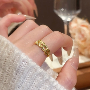 Close-up of 18k gold plated maple leaf bow ring with cubic zirconia on a female finger