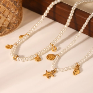 Golden starfish and shell pearl necklaces with rhinestones on a warm wooden display tray