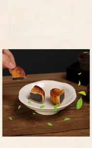 Detail of high-foot ceramic pastry plate with cracked glaze finish and traditional mooncakes