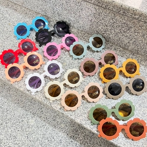 Detailed view of flower shaped kids sunglasses in various candy colors with UV400 protection