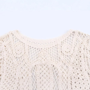 Detailed cream hollow crochet long sleeve top with intricate spiral patterns and round neck