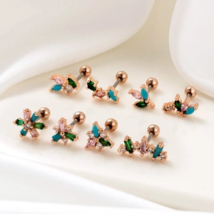 Detailed view of rose gold cartilage earrings set with turquoise and green cubic zirconia