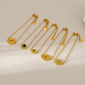 Detailed view of vintage gold-plated bracelets featuring diverse green natural stone charms