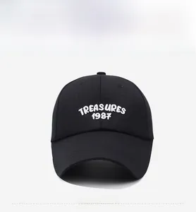 Close-up of white embroidered TREASURES 1987 lettering on black cotton baseball cap
