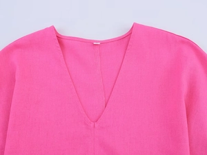 Gros plan du col en V rose vif montrant la texture détaillée du tissu en coton et lin