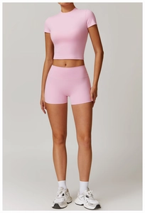 Pink yoga set featuring a cropped short-sleeve top and high-waist fitness shorts