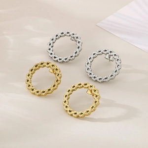 Detailed view of woven chain texture earrings in polished gold and silver steel finish