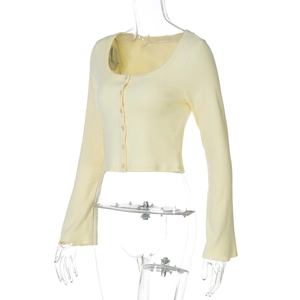 Detail view of a yellow knitted cardigan showing button closure and ribbed fabric texture