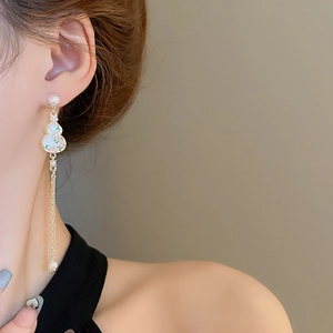 Close-up of Chinese style gourd earrings with enamel flowers, pearls and long tassels
