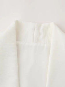 Detailed close-up of white vest collar showing vertical striped texture and clean stitching