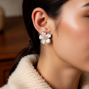Detail of vintage white enamel flower earring with turquoise beads and diamond accents