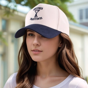 Detail of embroidered BIKINIS & MARTINIS text on cream and navy baseball cap