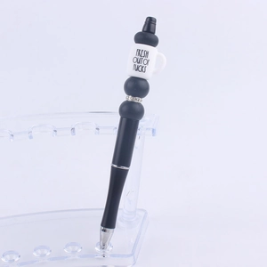Detail of DIY beadable pen with black beads and white coffee cup silicone topper
