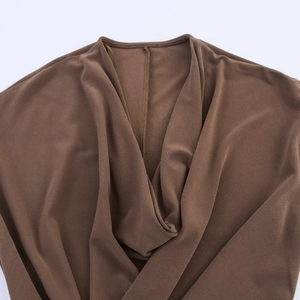 Détail du col bénitier élégant sur une robe sans manches marron à texture douce