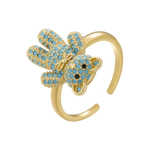 Detailed macro shot of a gold teddy bear ring with inlaid turquoise-colored gemstones