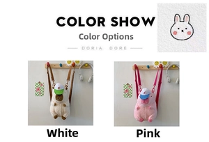 Detail view of plush capybara backpacks in white and pink with adjustable straps
