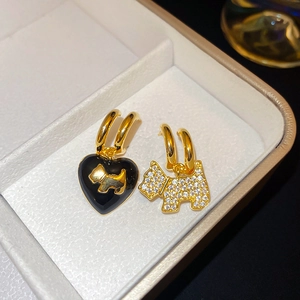 Macro detail of asymmetric puppy stud earrings with black heart and zircon stones