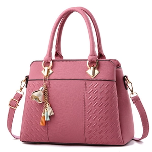 Pink lychee texture leather handbag with floral tassel pendant and adjustable shoulder strap