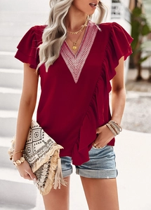 Detail of red V-neck blouse featuring white lace trim and ruffle sleeve accents