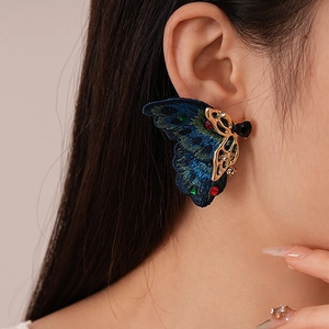 Gros plan de boucles d'oreilles papillon brodées vintage avec strass colorés sur un modèle
