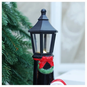 Detail of vintage Christmas lamp ornament with warm LED light and festive red bow decoration
