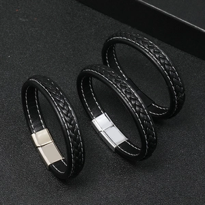Close-up of black braided leather bracelets with gold silver and black magnetic clasps