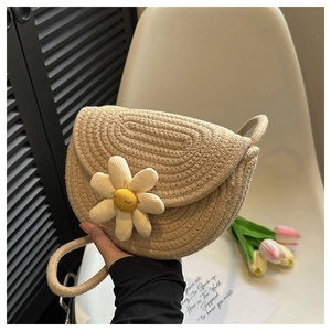 Detailed close-up of beige woven shoulder bag with a 3D white daisy floral decoration