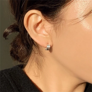 Close-up of minimalist 925 sterling silver striped hoop earring worn on earlobe
